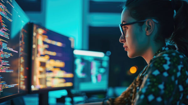 Programmer coding software, businesswoman working on computer in office.